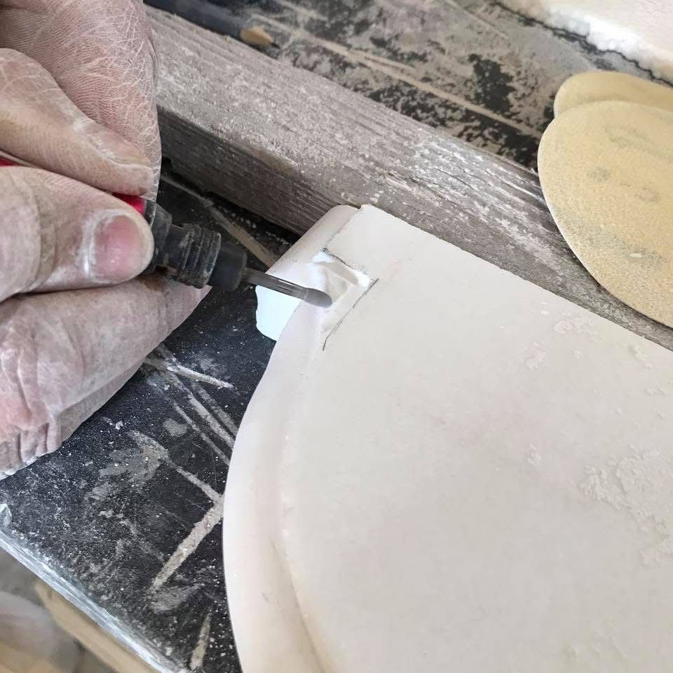 Rifinitura manuale del bordo di un piano in marmo pregiato