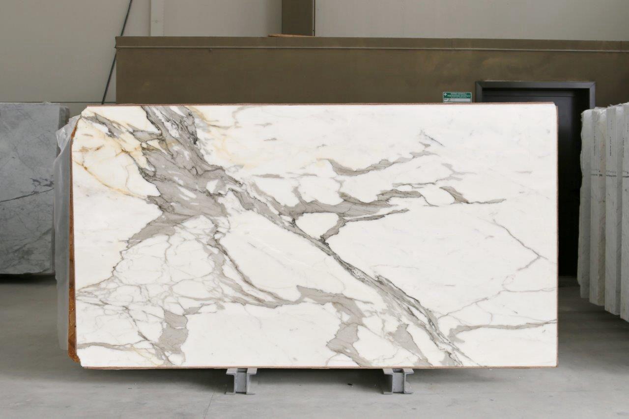 Una lastra di marmo bianco con venature dorate, in magazzino