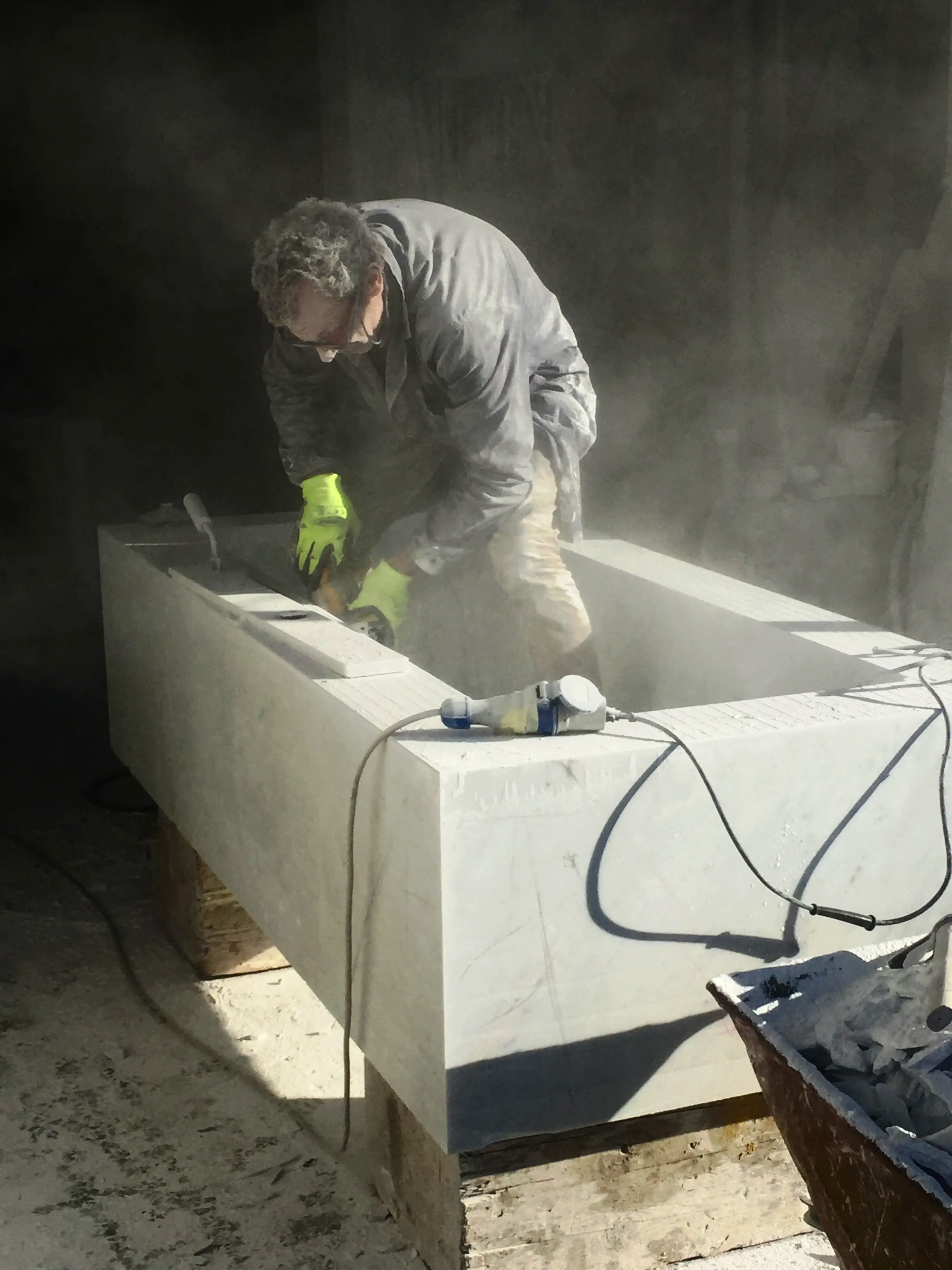 Maestro artigiano al lavoro nella lavorazione manuale del marmo nel laboratorio Marmo Elite Srl di Carrara